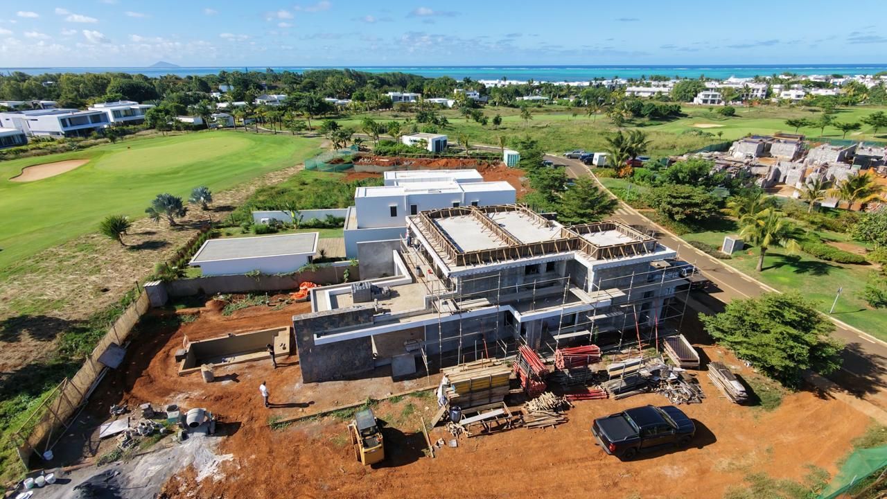 Aerial view of a villa under construction near a golf course