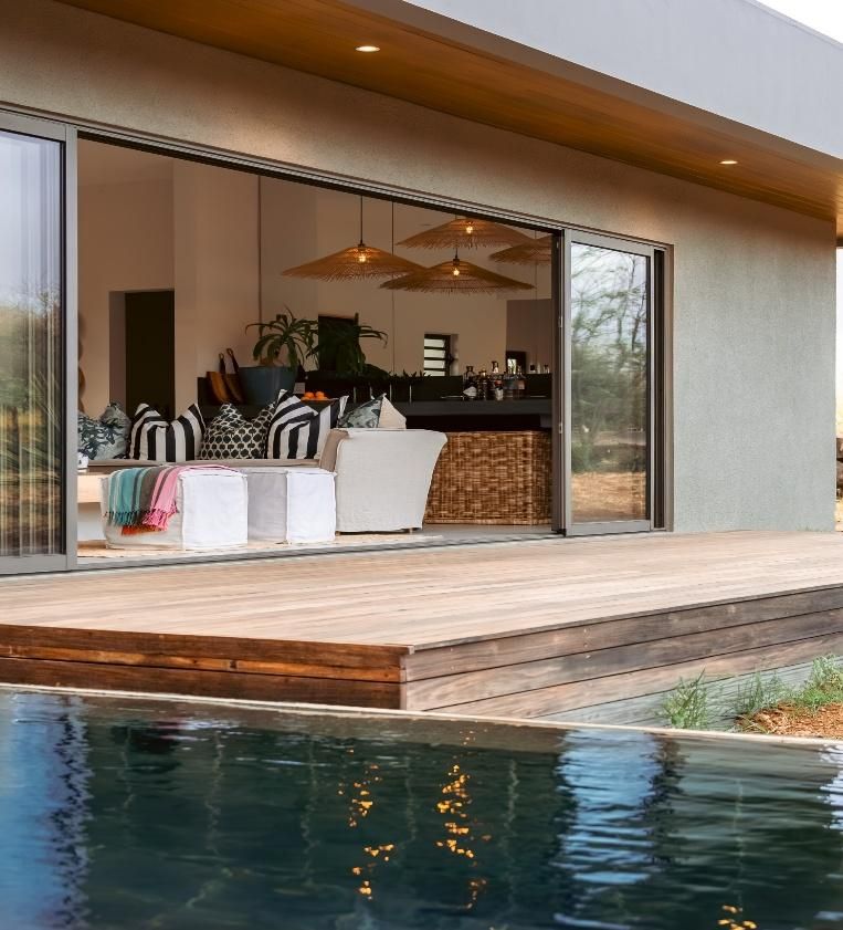 Living room opening onto a timber deck and pool